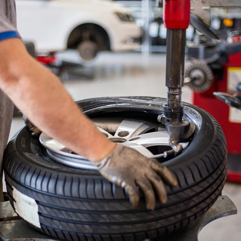 Photo of a mechanic working on fitting a tyre